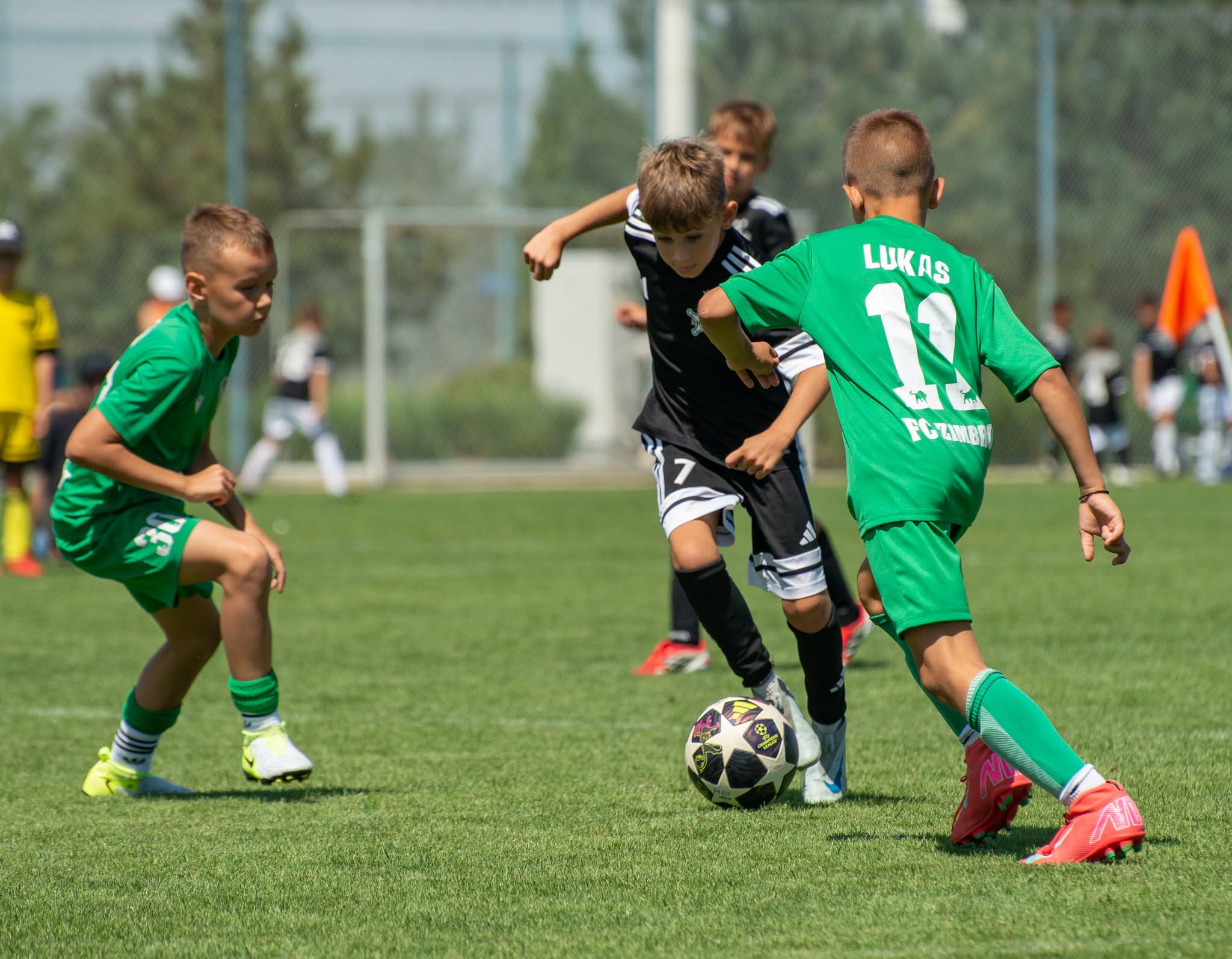 Copii jucând fotbal la un turneu de juniori